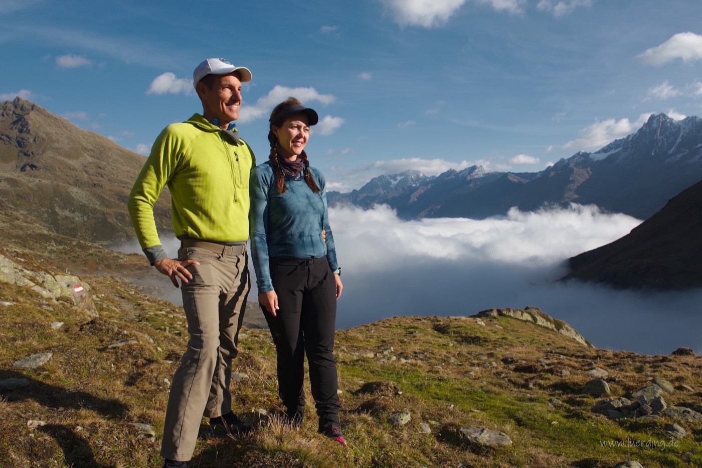 Zwei Wanderer auf einem Grat oberhalb der Wolkendecke