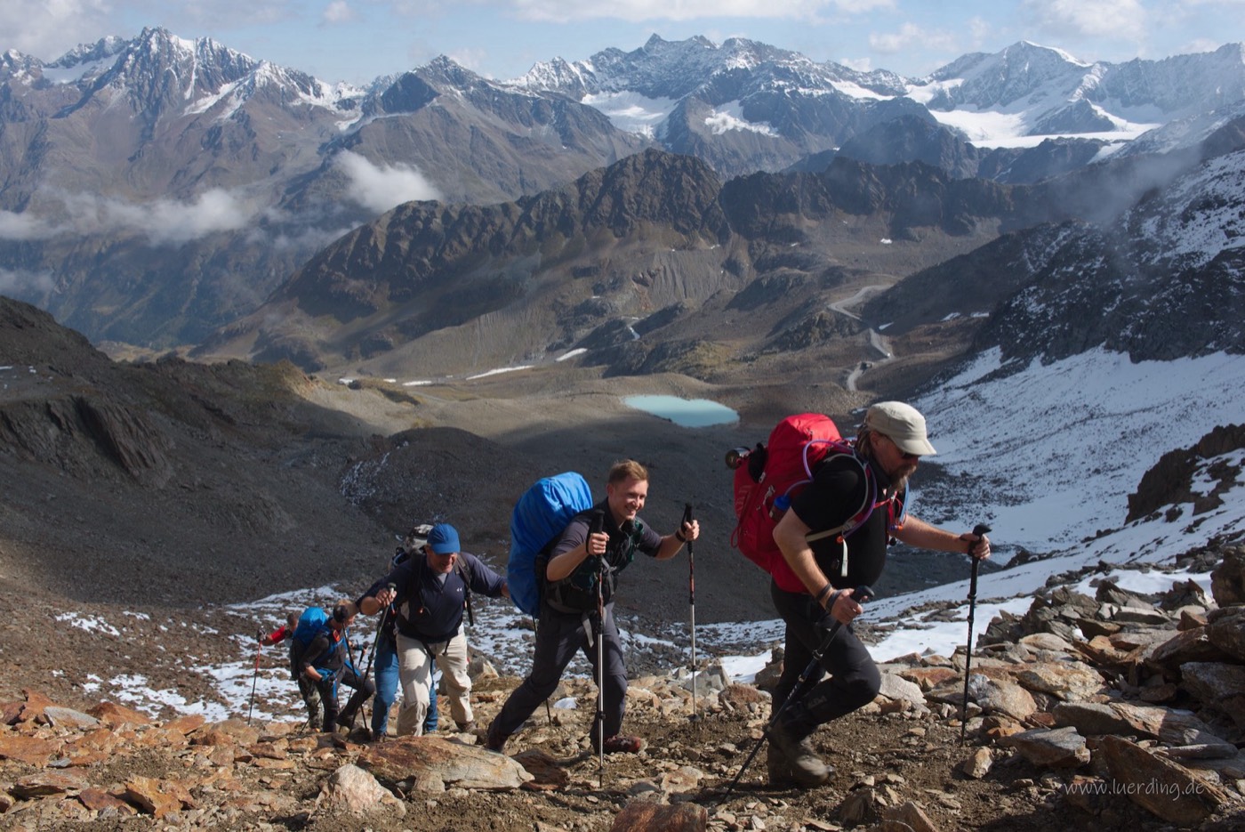 Schmaler Steig entlang einer Felsflanke, unten ein türkiser Bergsee